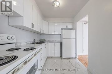 Toronto (Maple Leaf) condo for rent - A white kitchen with a stove top oven and a refrigerator.