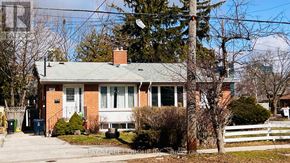 Toronto (Parkwoods-Donalda) apartment for rent - A house with a green roof and a white fence.