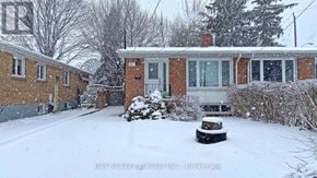 Toronto (Parkwoods-Donalda) apartment for rent - A snow-covered yard with a brick house and a fence.