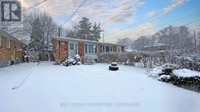 Toronto (Parkwoods-Donalda) apartment for rent - A snow-covered yard with a house and trees in the background.