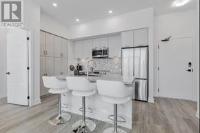 Innisfil condo for rent - A modern kitchen with white chairs and a bar stool.