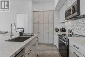 Innisfil condo for rent - A modern kitchen with a stainless steel sink and oven.