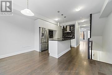 Oakville (Go Glenorchy) townhouse for rent - A spacious kitchen with white cabinets and a black countertop.