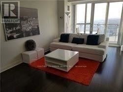Mississauga (City Centre) condo for rent - A living room with a white couch and a red rug.