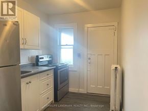 Hamilton (Crown Point) multi-family for rent - A small kitchen with white cabinets and a stainless steel refrigerator.