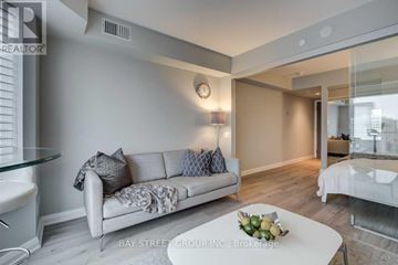 Toronto (Annex) condo for rent - A modern living room with a glass table and a white sofa.