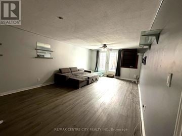 Brantford apartment for rent - A living room with a couch and a fan.