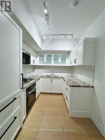 Toronto (Englemount-Lawrence) condo for rent - A kitchen with white cabinets and a granite countertop.