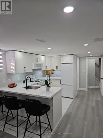 Brantford apartment for rent - A modern kitchen with white cabinets and a center island.