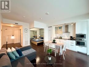 Toronto (Waterfront Communities) condo for rent - A modern living room with a grey couch and a dining table set up.