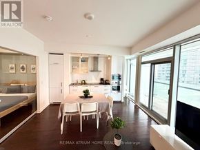 Toronto (Waterfront Communities) condo for rent - A well-lit, modern kitchen with a dining table set for four.