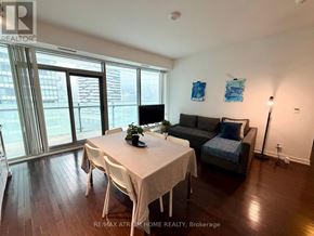 Toronto (Waterfront Communities) condo for rent - A dining room with a table set for two and a couch.