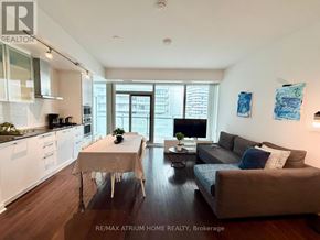 Toronto (Waterfront Communities) condo for rent - A well-lit, modern open-plan living and dining area with a kitchen in the background.