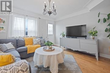 Burlington (Freeman) apartment for rent - A living room with a grey couch, a white coffee table, and a television on a cabinet.