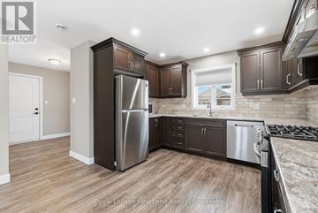 South Bruce townhouse for rent - A kitchen with dark wood cabinets and stainless steel appliances.