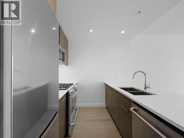 Burnaby apartment for rent - A modern kitchen with a refrigerator on the left and a sink on the right.