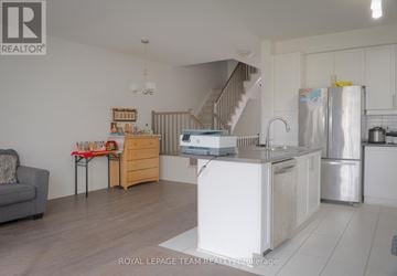 Ottawa townhouse for rent - A kitchen with a refrigerator, sink, and stove is shown in this image.