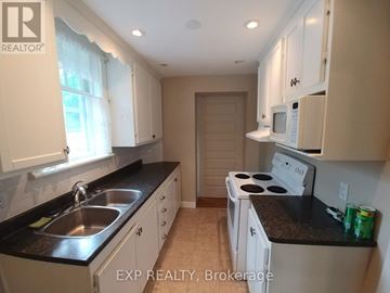 Ottawa apartment for rent - A kitchen with white cabinets and a black countertop.