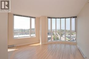 Vancouver apartment for rent - A large empty room with a view of the city through the windows.