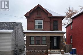 Hamilton (Landsdale) apartment for rent - A red brick house with a black door and windows is in front of a grey house and a red building.