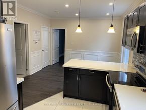 Oshawa (O'neill) duplex for rent - A kitchen with black cabinets and a white counter top.