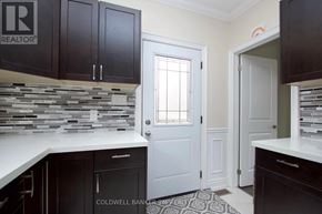 Oshawa (O'neill) duplex for rent - A kitchen with black cabinets and a stone backsplash.