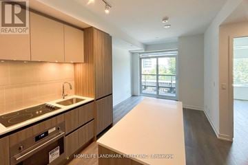 Vaughan (Beverley Glen) condo for rent - A kitchen with wooden cabinets and a stove top oven.