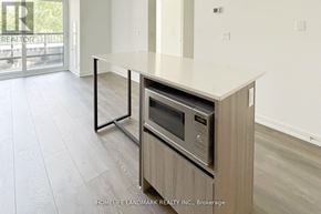 Vaughan (Beverley Glen) condo for rent - A modern kitchen with a stainless steel oven built into a wooden cabinet.