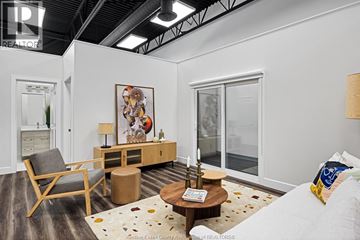 Lakeshore condo for rent - A living room with a wooden chair, a brown coffee table, and a painting on the wall.