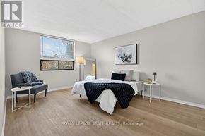 Hamilton (Stoney Creek) condo for rent - A bedroom with a bed, chair, and lamp.