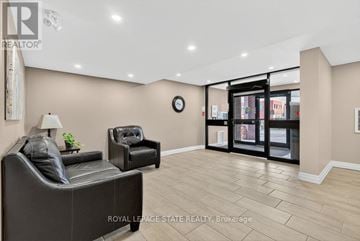Hamilton (Stoney Creek) condo for rent - A living room with a black leather sofa and a wooden side table.