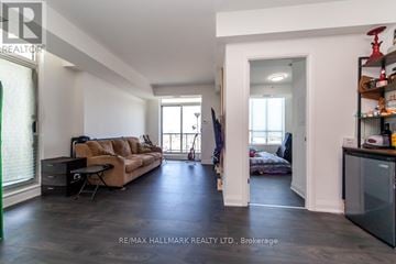 Toronto (Scarborough Village) condo for rent - A spacious living room with a brown sofa and a black refrigerator.