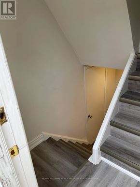 Toronto (Lansing-Westgate) apartment for rent - A staircase with a white door on the left and a light on the right.