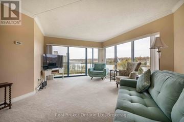 Owen Sound condo for rent - A living room with a green couch and a television.