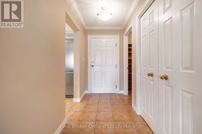 Owen Sound condo for rent - A hallway with white doors and a Real Broker logo.