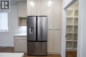 Sarnia apartment for rent - A stainless steel refrigerator in a kitchen with white cabinets.