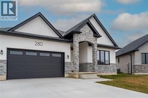 Sarnia apartment for rent - A modern house with a stone pillar entrance and a black garage door.
