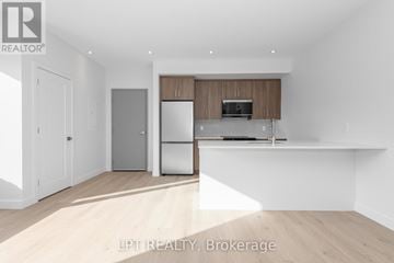 Ottawa multi-family for rent - A modern kitchen with wooden cabinets and stainless steel appliances.