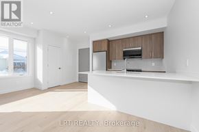 Ottawa multi-family for rent - A spacious kitchen with wooden cabinets and a stainless steel refrigerator.