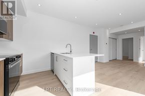Ottawa multi-family for rent - A modern kitchen with white cabinets and a wooden island.