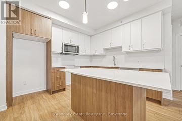 Cambridge condo for rent - A kitchen with white cabinets and a wooden island.