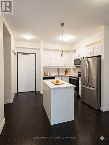 Waterloo condo for rent - A kitchen with white cabinets and a refrigerator.