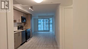 Pickering (Bay Ridges) condo for rent - A kitchen with wooden cabinets and black appliances is shown.