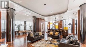 Toronto (Islington-City Centre West) condo for rent - A living room with a black couch and a coffee table.