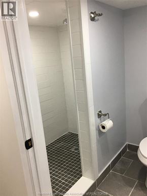 Windsor apartment for rent - A white bathroom with a toilet and a walk in shower.