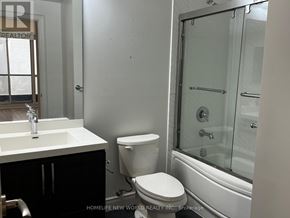Markham (Unionville) condo for rent - A white toilet sits next to a sink in a bathroom.