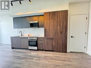 Toronto (Centennial Scarborough) condo for rent - A modern kitchen with a wooden cabinet and a stove top oven.
