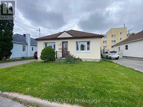 Ottawa apartment for rent - A house with a brown roof and a small front yard.