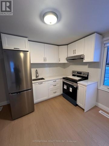 Vaughan (West Woodbridge) townhouse for rent - A kitchen with white cabinets and a stainless steel refrigerator.
