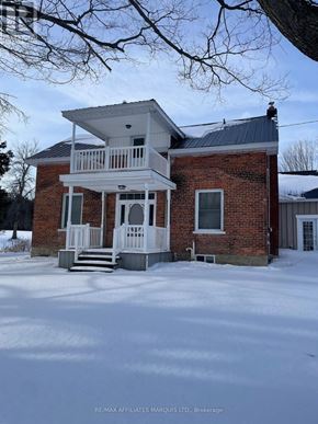South Glengarry apartment for rent - A house with a white porch and a brick exterior is shown in the image.